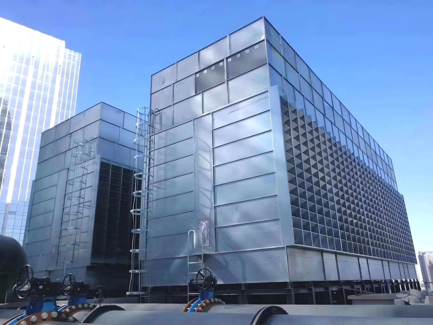 Cooling towers beside a glass high-rise